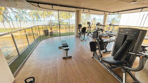 A gym with cardio machines, free weights, and a bench. - Yacht - by Setai Apartaments (João Pessoa)