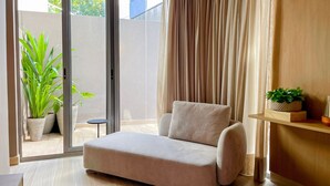 A modern living room with a sofa, a small table, and a potted plant. - Yacht - by Setai Apartaments (João Pessoa)