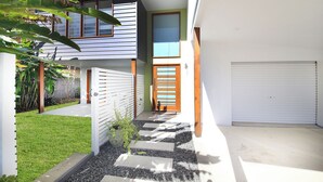 Uma casa moderna com garagem, varanda coberta e um gramado bem cuidado.