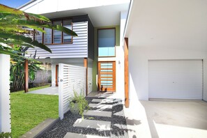 Een modern huis met een garage, een overdekte veranda en een verzorgd gazon.