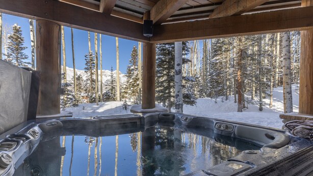 A hot tub with a view of a snowy forest. - Ute Lodge | Hot Tub, Walk to Trails, Big Views! (Mountain Village)