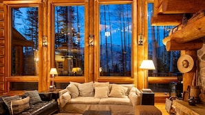 A cozy log cabin interior with a leather sofa, a wooden coffee table, and a stone fireplace. - Ute Lodge | Hot Tub, Walk to Trails, Big Views! (Mountain Village)