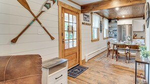 Eine Küche mit Holzschränken, einem Edelstahlkühlschrank und einem Essbereich mit Holztischen und einem Tisch.