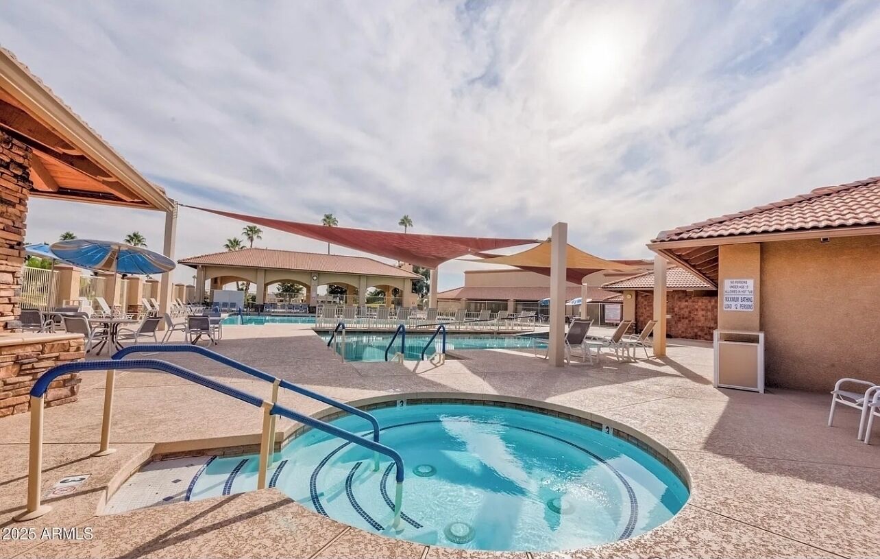 A pool area with multiple swimming pools, lounge chairs, and shaded areas.
