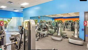 A gym with various exercise machines, a mirrored wall, and a blue and orange color scheme. - Leisure World Oasis. Charming 2-bedroom townhome. 24 Hours security in Mesa (Mesa)