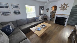 A living room with a grey sectional sofa, a wooden coffee table, and a fireplace.