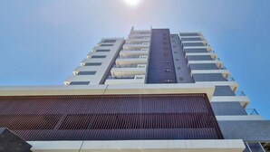 Un immeuble moderne et imposant, doté de nombreux balcons et fenêtres.