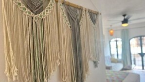 A macrame wall hanging with a wooden rod.