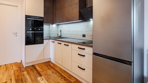 A modern kitchen with built-in appliances, wooden flooring, and a white door. - Modern apartment just a 20-minute walk from the historic center of Lucca (Lucca)