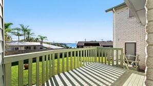A wooden deck with a view of the ocean and palm trees. - 53 Long Point, Potato Point - Hidden Coastal Retreat (Potato Point)