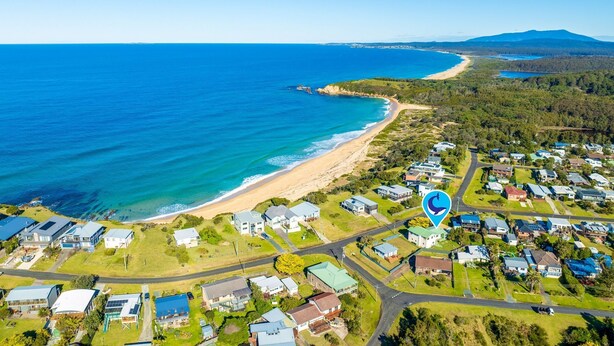 An aerial view of a coastal residential area with houses, a beach, and a clear view of the ocean. - 53 Long Point, Potato Point - Hidden Coastal Retreat (Potato Point)