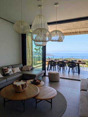 A modern living room with a large window overlooking a coastal view.