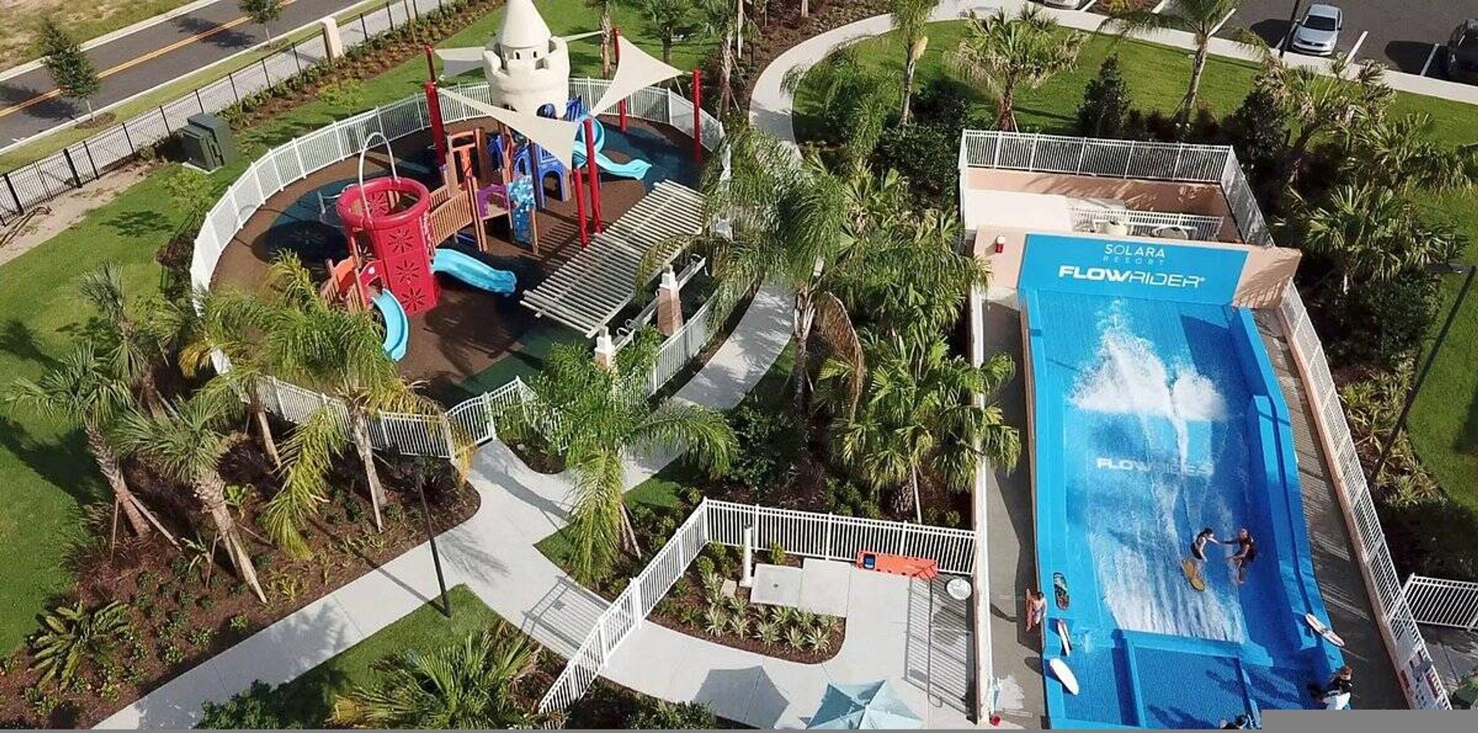 Een waterpark met een groot zwembad, glijbanen en een kasteelachtige constructie.