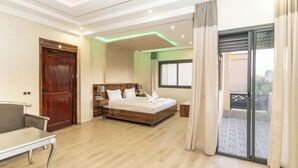 A bedroom with a bed, bedside table, and a view of the outside through a sliding door. - Villa in the heart of Marrakech city center, with a private pool. (Marrakesh)
