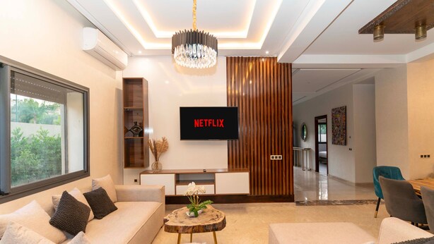A modern living room with a sofa, coffee table, and a flat-screen TV displaying 'NETFLIX'. - Villa in the heart of Marrakech city center, with a private pool. (Marrakesh)