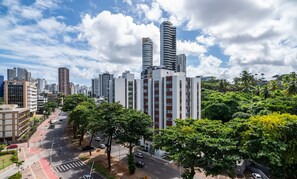 A cityscape with modern high-rise buildings, a clear sky, and a street lined with trees. - Charming Apt Just 750m From the Beach! Bca0601 (Salvador)