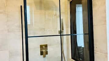 Banheira e chuveiro separados, secador de cabelo, toalhas de banho