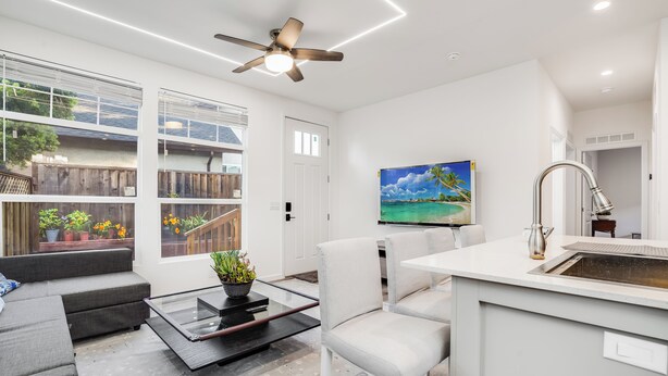 A modern living room with a sofa, a coffee table, and a TV mounted on the wall. - Privately Secluded 2-BR Guesthouse in Fremont (Fremont)
