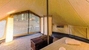A tent with a bed, a wooden chest, and a window. - OAK glamping relax, CAUTHA cushy tent romantic and stylish, in a magical forest (Manziana)