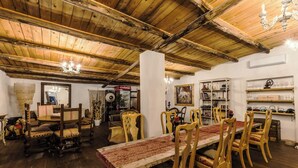 A dining area with wooden furniture, a chandelier, and shelves with glassware. - OAK glamping relax, CAUTHA cushy tent romantic and stylish, in a magical forest (Manziana)