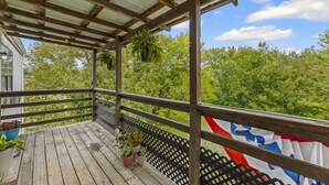Una terraza de madera con plantas en macetas y la bandera del estado de Texas.