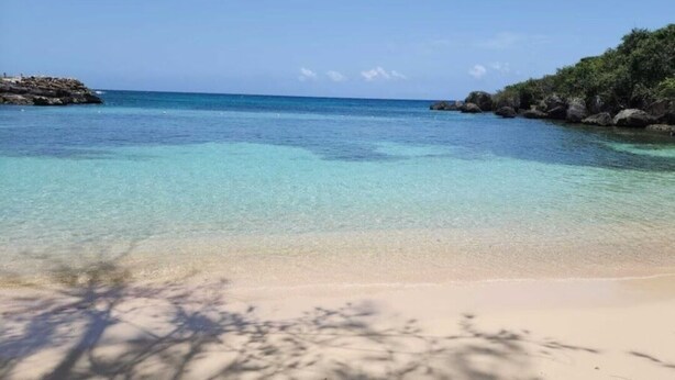 A beach with clear turquoise water, sandy shore, and rocky outcrops. - Cozy 3-bedroom villa w/ AC, pool & unlimited beach access 10 mins from Ocho Rios (Saint Ann's Bay)