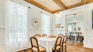 Un comedor con una mesa redonda, seis sillas y una araña.