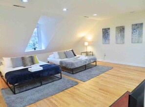 A modern loft bedroom with two beds, a skylight, and artwork on the walls. - In the heart of Center City! Large bi-level 3/2 (Philadelphia)
