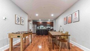 Una cocina moderna con armarios de madera oscura, una isla central y una zona de comedor con mesa y sillas de madera.