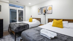 Une chambre d’hôtel avec deux lits, une armoire, un bureau et une fenêtre donnant sur un paysage agréable.