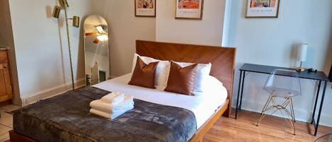 Escritorio, tabla de planchar con plancha, wifi y ropa de cama