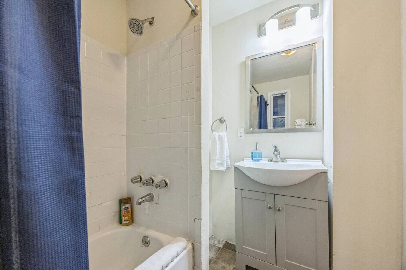 Une salle de bain avec une baignoire, un lavabo, un miroir et une douche.