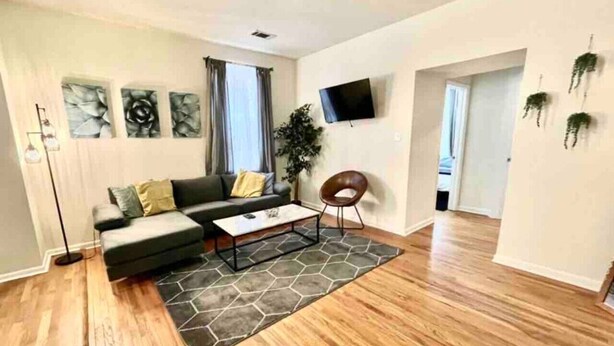 Un salon moderne avec un canapé, une table basse et un tapis décoratif.