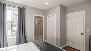 Une chambre à coucher avec un lit, une douche et deux portes.