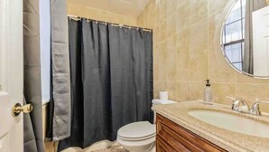 A bathroom with a toilet, sink, and shower curtain.