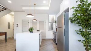 Una cocina moderna con una isla central, electrodomésticos de acero inoxidable y una planta en maceta.