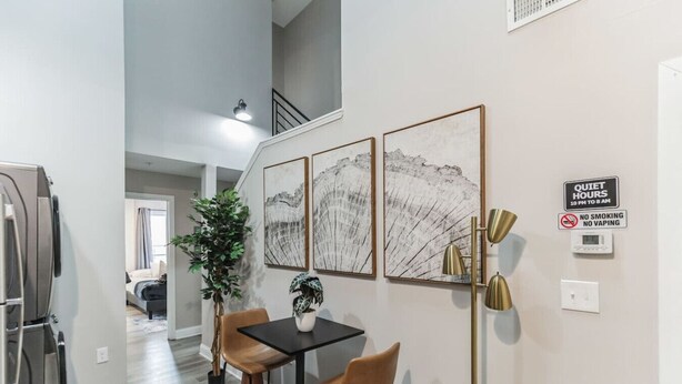 Une cuisine moderne avec un coin repas, un escalier et une vue sur le salon.