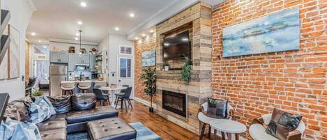 Una sala de estar moderna con chimenea, sofá de cuero y comedor.