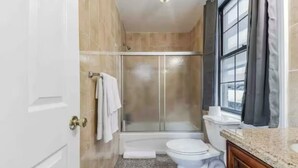 Een badkamer met een douche, toilet en wastafel.