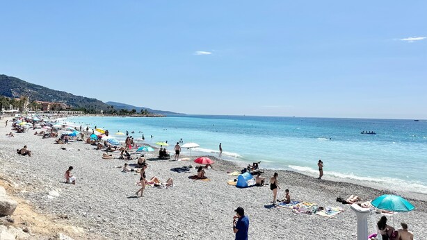 A crowded beach with people sunbathing and swimming, umbrellas, and a tent. - 100M FROM THE CASINO, LOVELY 3-ROOM APARTMENT WITH SEA VIEW AND BIJOU GARDENS. PRIVATE PARKING. (Menton)