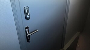 Μια πόρτα με μια πινακίδα που φέρει τον αριθμό 3, ένα πληκτρολόγιο και μια τρύπα για το κλειδί.