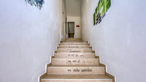 Un escalier dont les marches sont ornées de phrases motivantes, menant à une pièce.