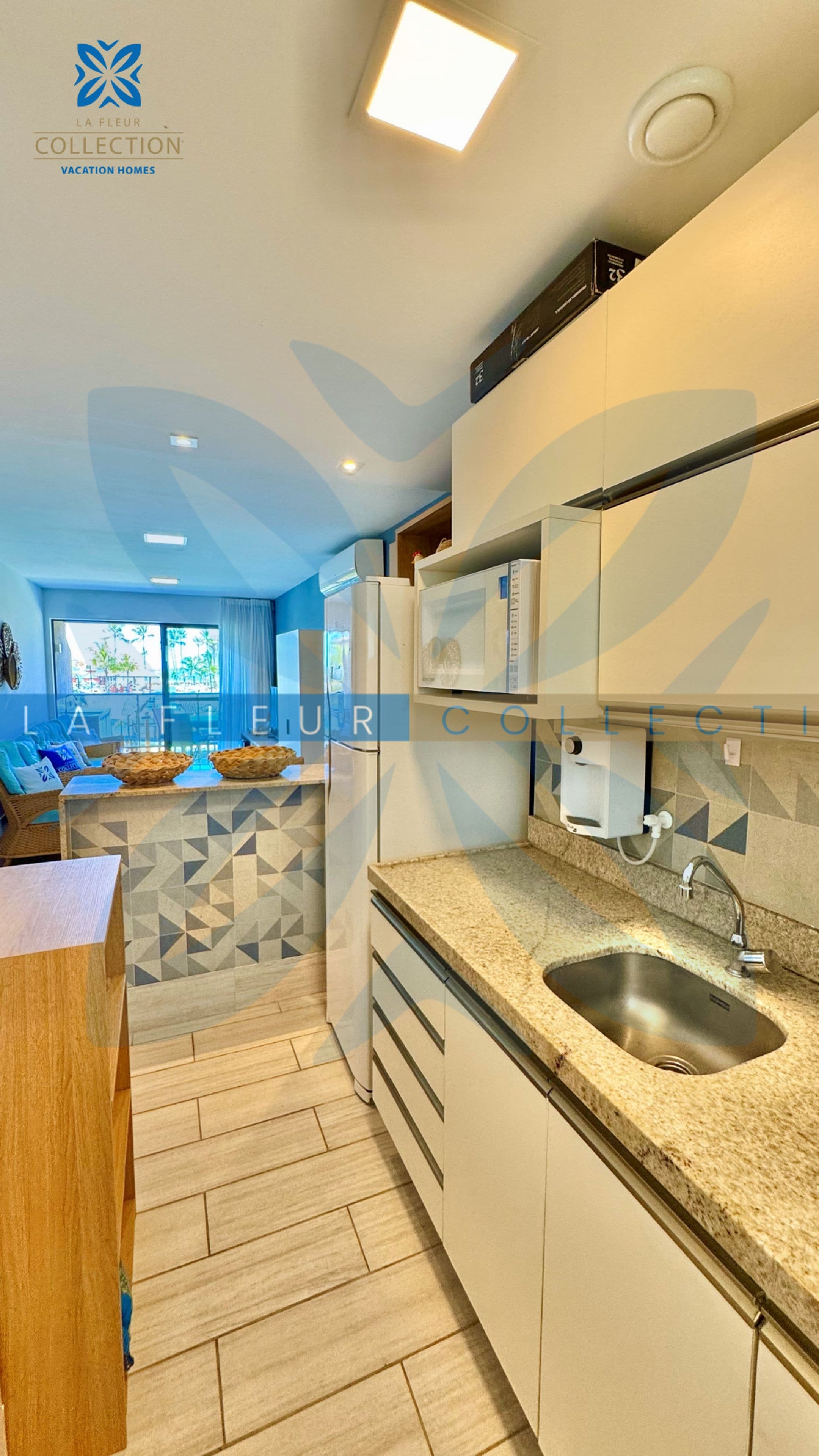 A modern kitchen with a granite countertop, stainless steel sink, and built-in appliances.