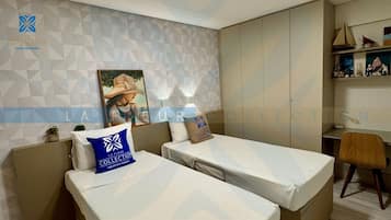 Quarto de hotel com duas camas, uma mesa e uma cadeira. Uma parede com padrões geométricos e um pôster.