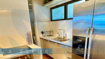 Departamento Deluxe, varias camas, vista al mar | Cocina privada | Refrigerador, microondas, periquera y utensilios de cocina