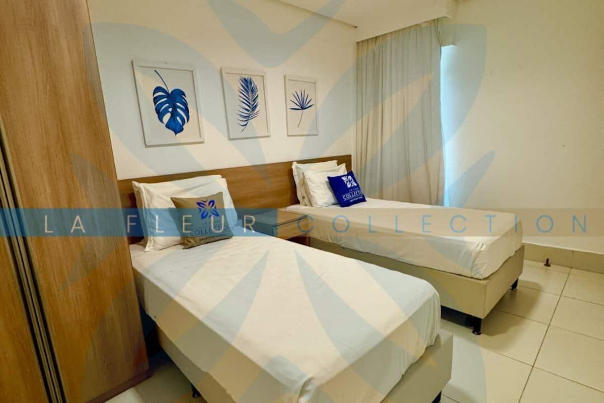 Ein Hotelzimmer mit zwei Betten, einem Holzschrank und einem Badezimmer mit Badewanne.
