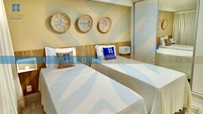 A hotel room with two beds, a large mirror, and decorative wall art. - La Fleur Collection Vacation Homes (Ipojuca)