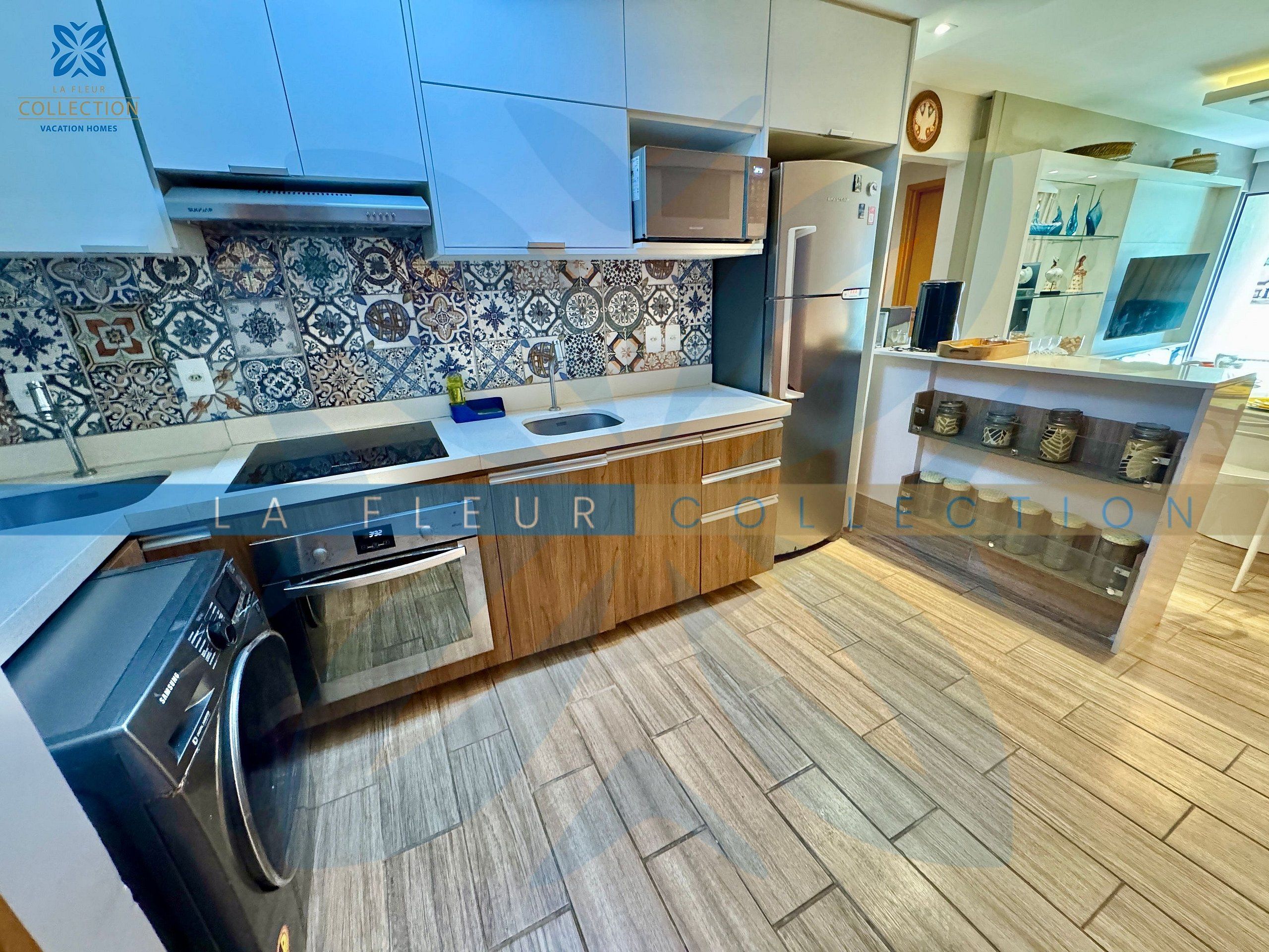 A modern kitchen with a patterned backsplash, stainless steel appliances, and wooden cabinetry.