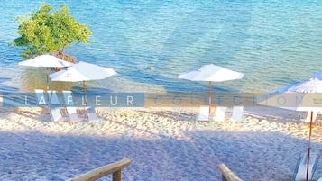 On the beach, white sand, sun-loungers, beach umbrellas