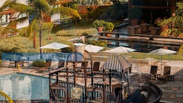 Área de piscina com toboáguas, espreguiçadeiras e guarda-sóis.
